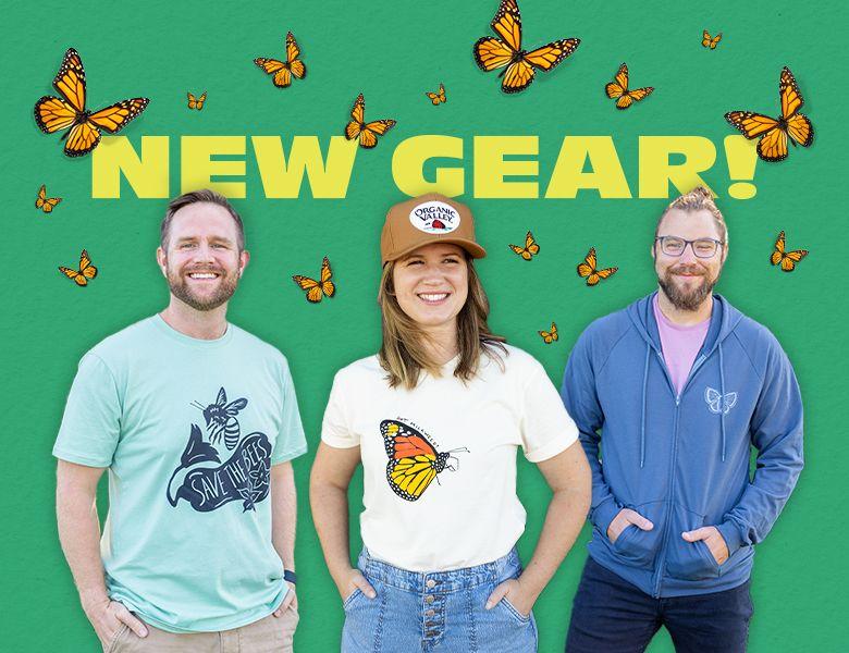 3 people standing against a green background with butterflies wearing new Organic Valley pollinator gear 