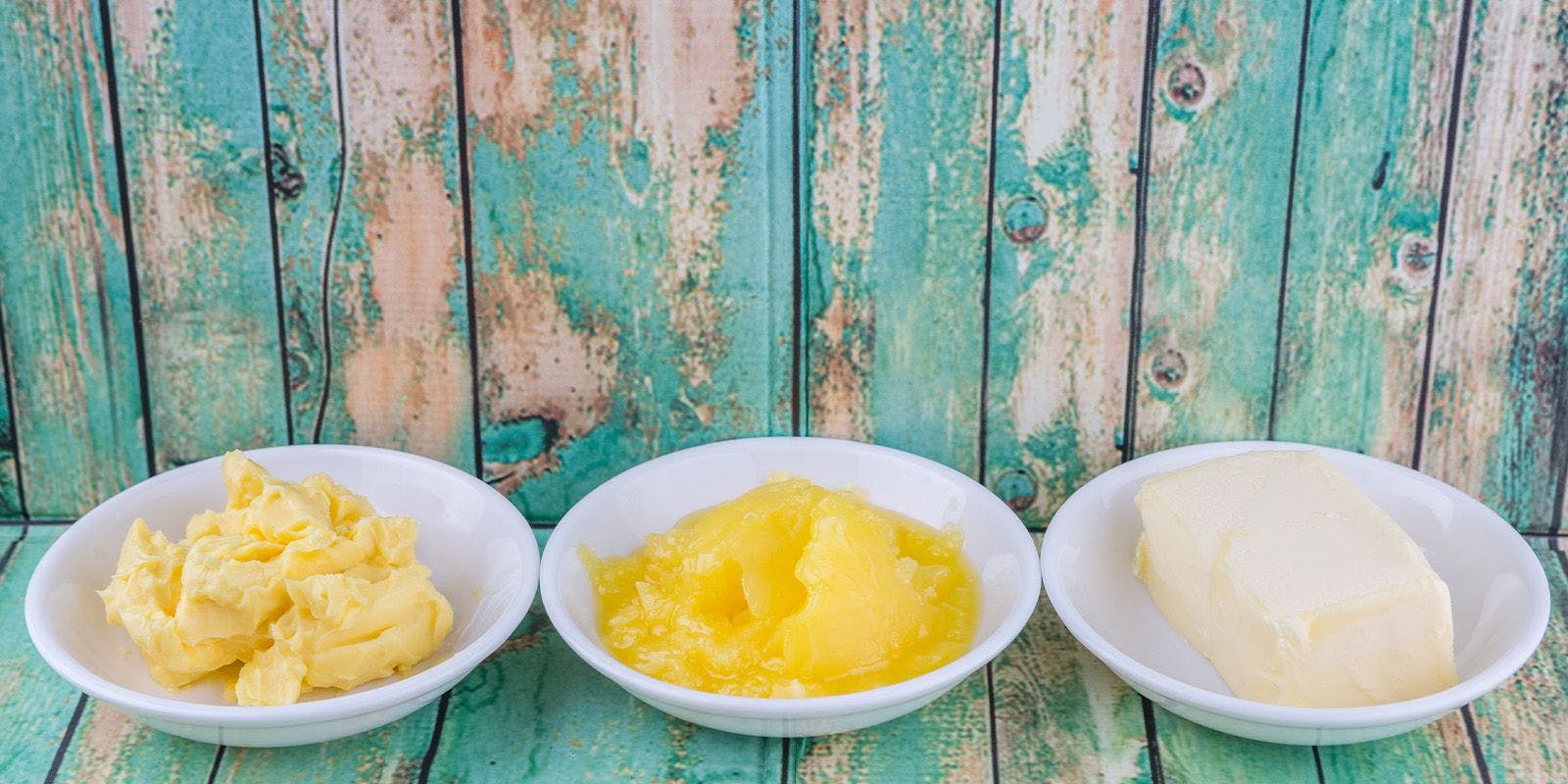 Three bowls in a row; one with butter, one with ghee, one with margarine.