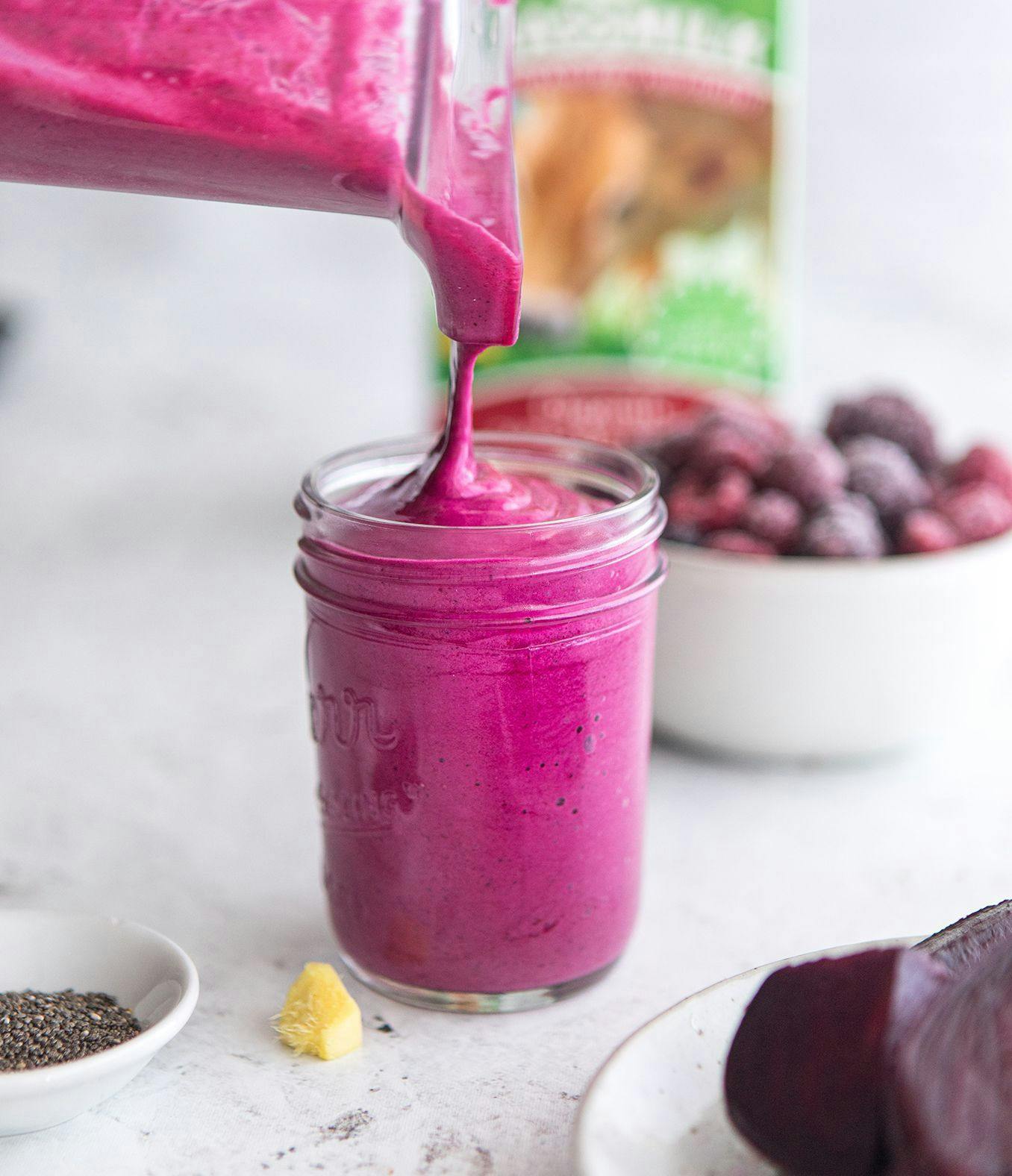 Berry Beet Smoothie being poured into a glass jar. 