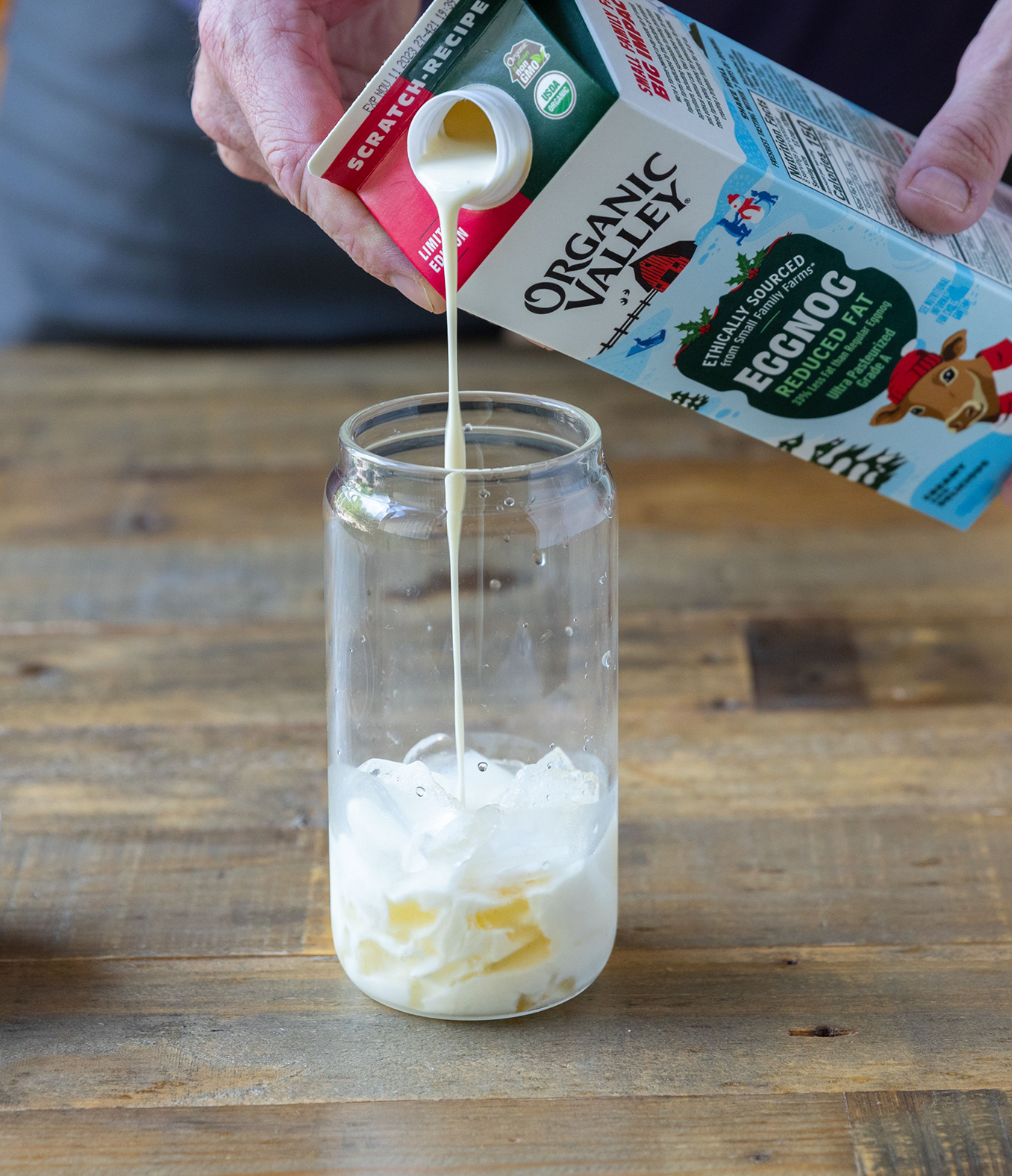 Organic Valley Eggnog being poured into a glass with ice. 