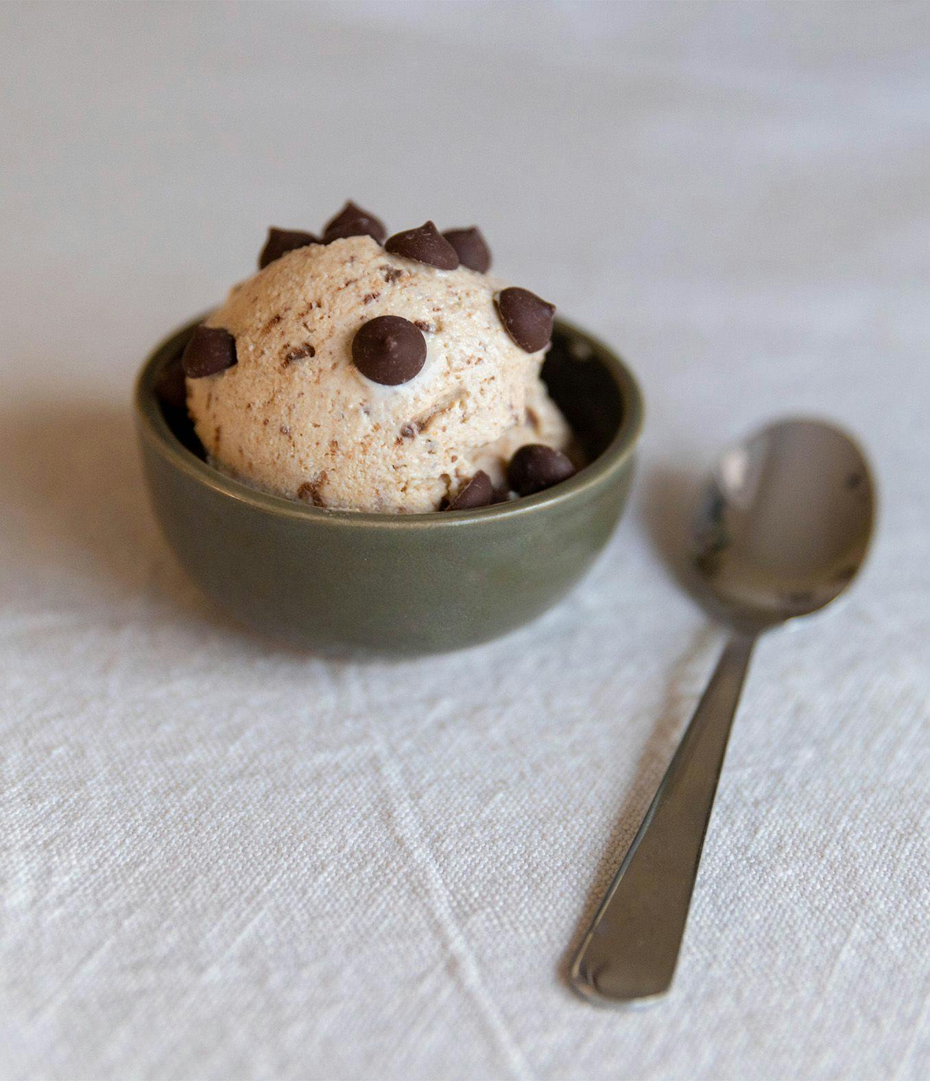 Scoop of cottage cheese ice cream in a dish with chocolate chips and spoon.